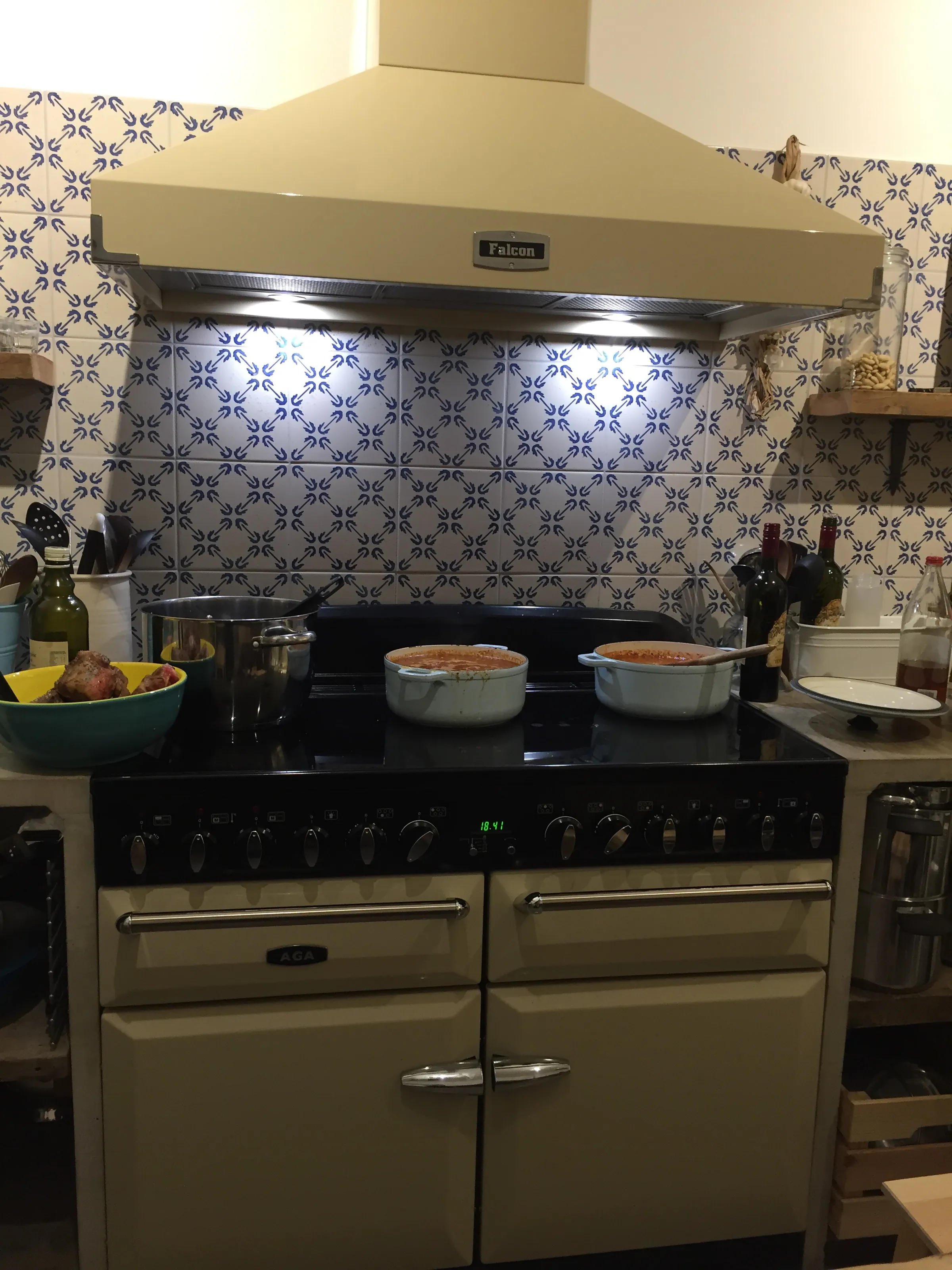 Ett hemtrevligt kök med vitt kakel, öppna hyllor och kopparkärl i den italienska matlagningslokalen.