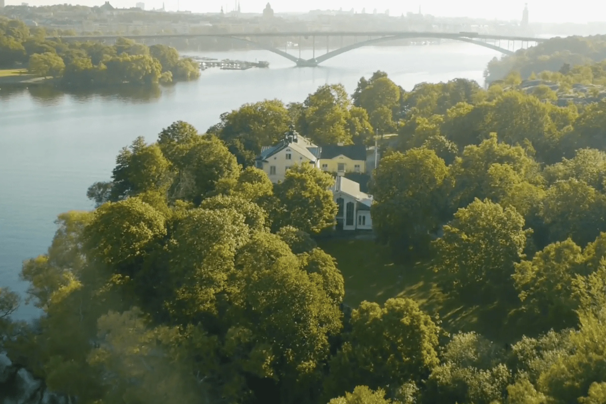 Carlshälls Gård på Långholmen omgiven av grönska och Mälaren.